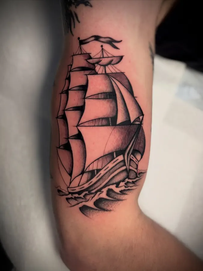 Voilier traditionnel tatoué sur un avant-bras.