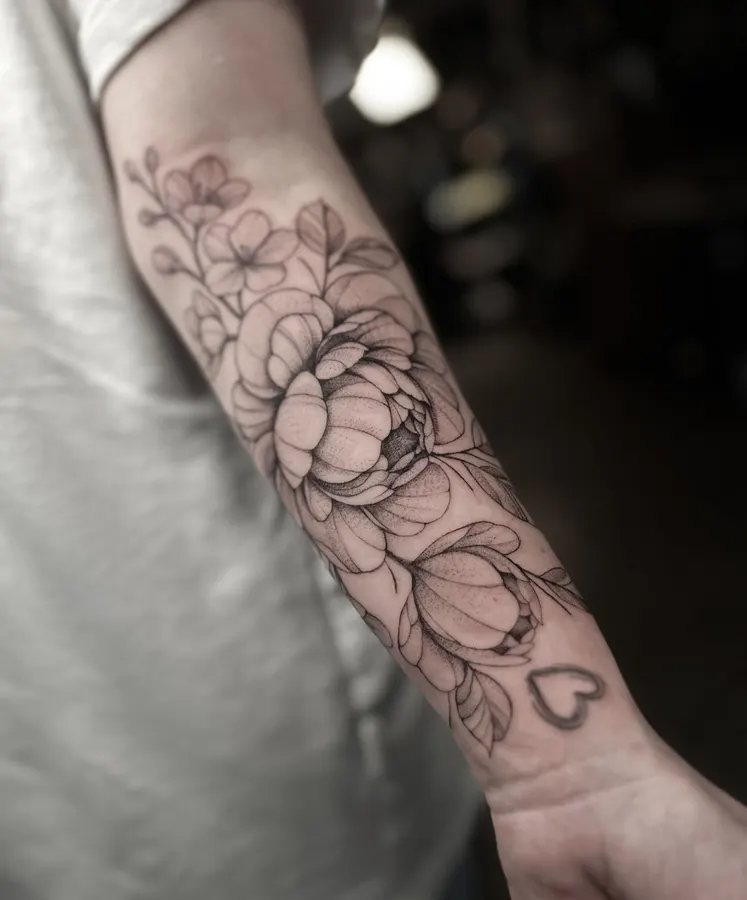 Tatouage floral délicat sur un avant-bras.
