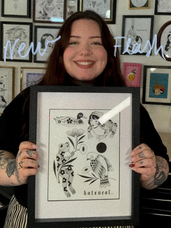 Kat présente une de ses illustrations encadrées.